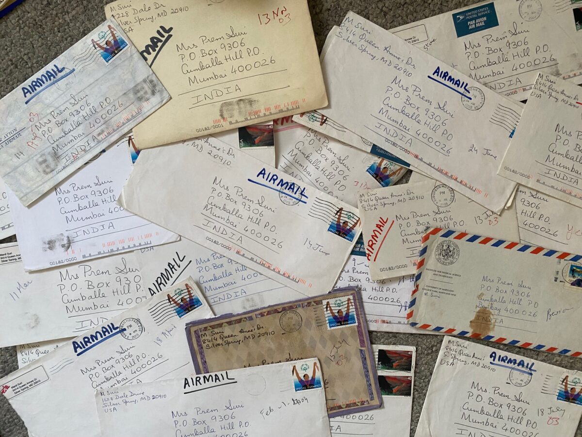 A strew pile of old letter envelopes with different stamps and designs and handwriting all to a Mrs. Prem Suri, Manil Suri's mother
