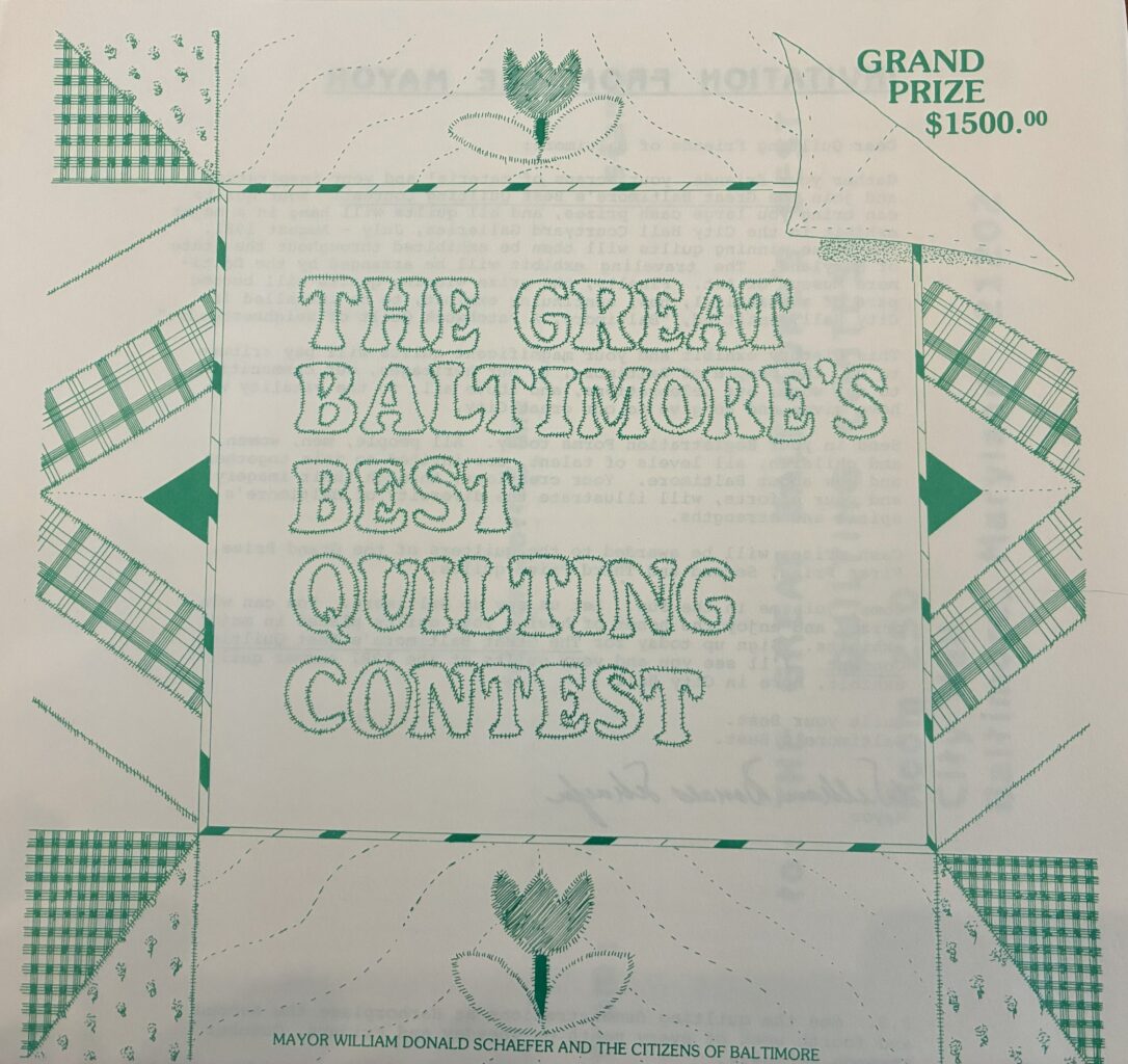 A green and white quilt with the words The Great Baltimore's Best Quilting Contest sewn into it and Grand Prize $1500 sewn on the top right hand corner