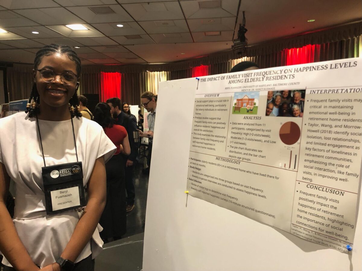 a college junior stands with her poster presentation about aging care