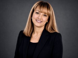Portrait of Gamze Zeytinci smiling and wearing a black shirt and black blazer