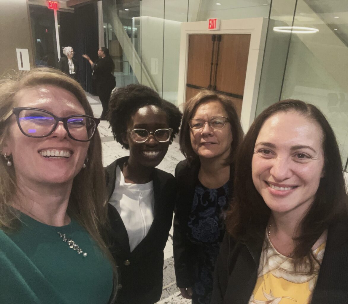 Erika Bucciantini and three other public policy researchers stand together for a group picture in a conference hallway