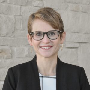Headshot of Christia Spears Brown with short brown hair wearing glasses.