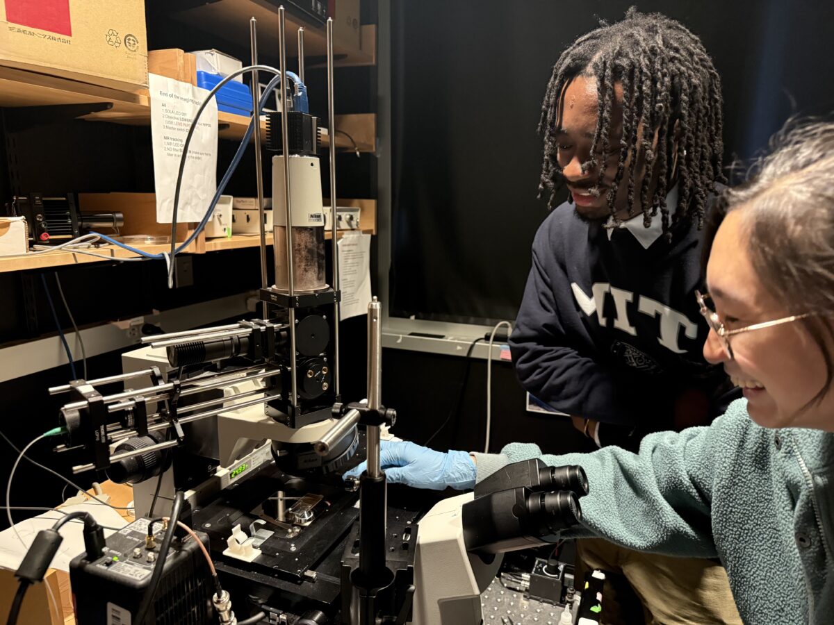 Amir Walton-Irvin, a Cech Fellow, and a graduate student mentor work with a microscope in the lab