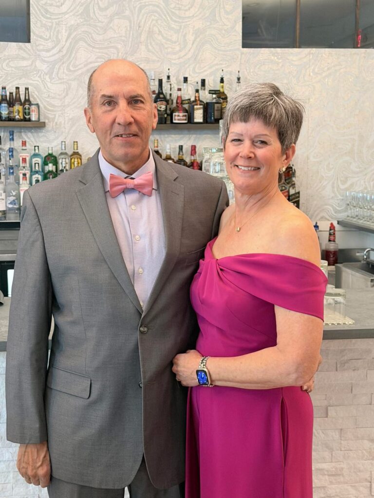 Jay Offutt and Pam Offutt dressed up and posing for the camera.