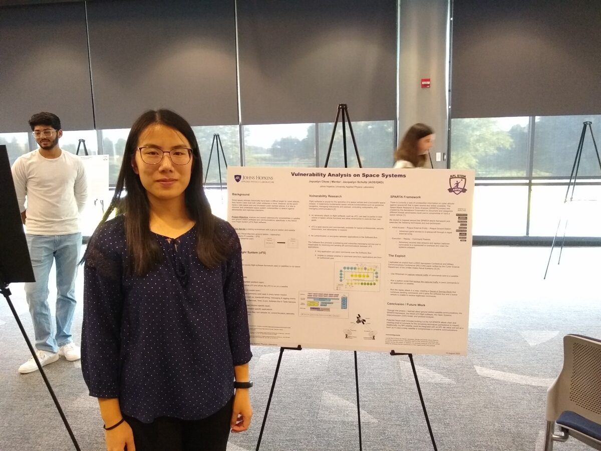 Chow stands next to a scientific poster.