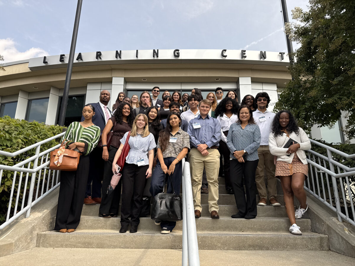 a group of WTCI Albrecht fellows stand on the steps outside a building with the words Learning Center on the front