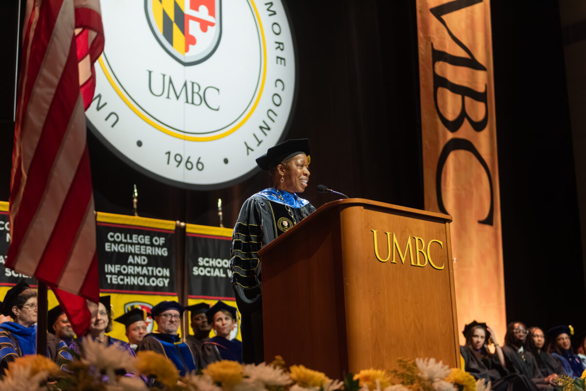 president valerie sheares ashby stands at an official podium on the stage of convocation addressing new students