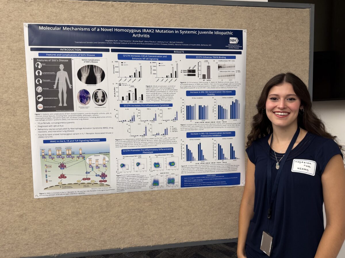 Magdalen Ruth stands beside her research poster