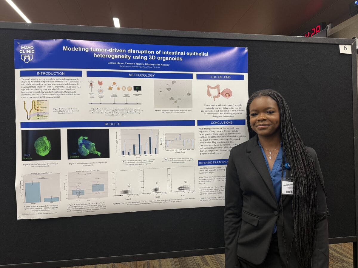 Zainab Idowu stands beside her research poster