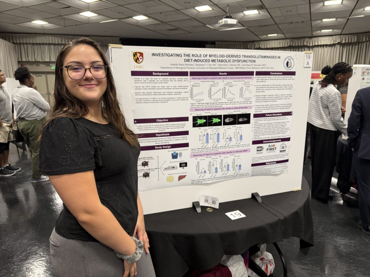 Izabella Marzano standing next to her research poster, titled, "Investigating the role of myeloid-derived transglutaminases in diet-induced metabolic dysfunction"