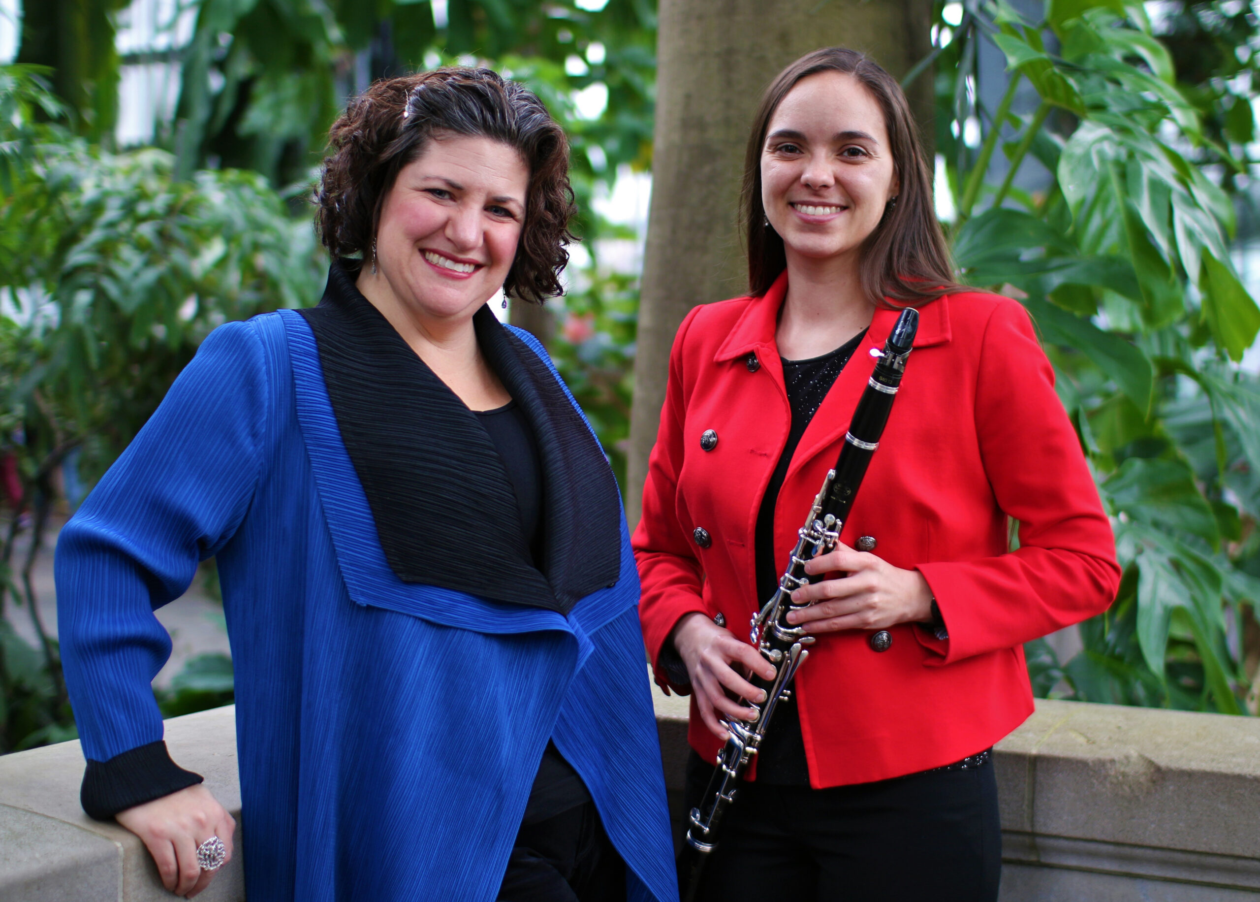Two people stand together, one holding a clarinet.