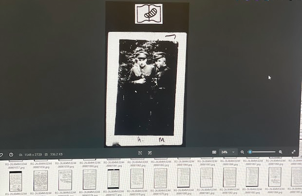 A poor quality black and white photo of two WWII soldiers with their arms wrapped around each other's shoulders.
