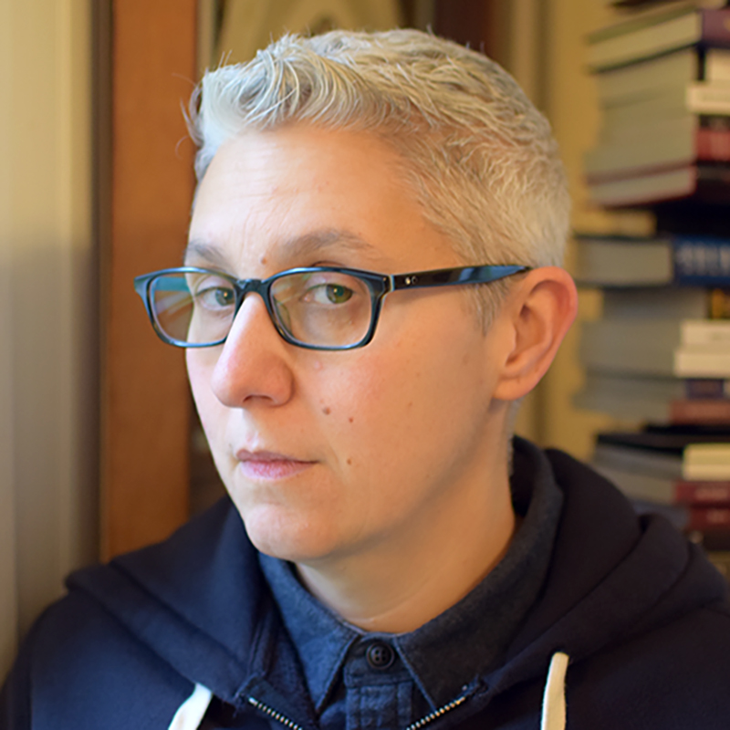 Headshot of a person with short gray hair and glasses.