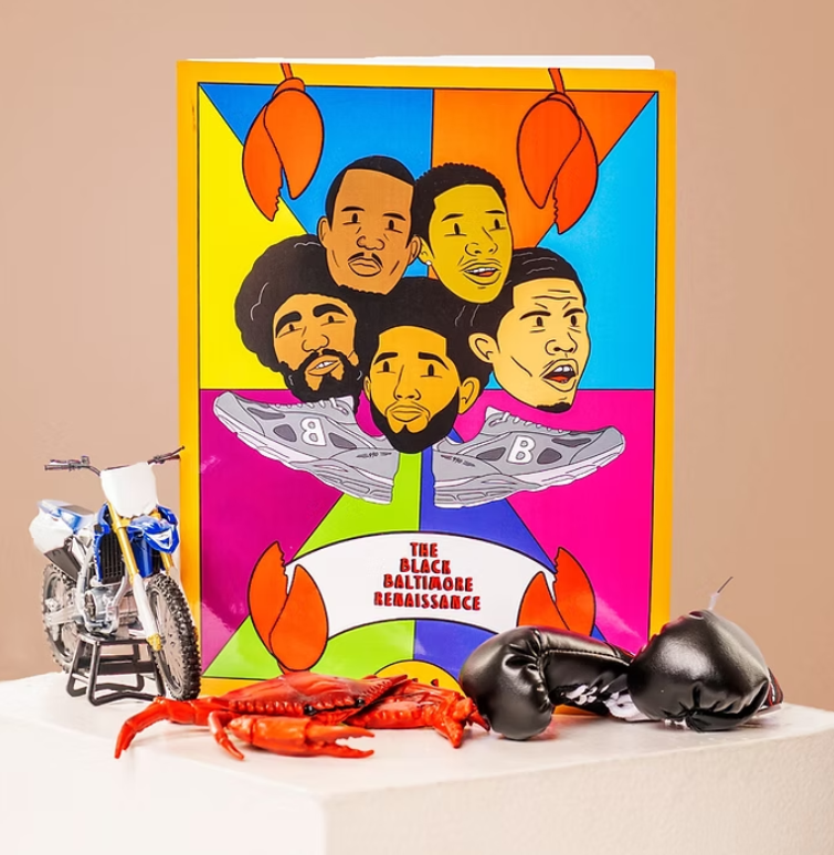 Black Baltimore Renaissance Coloring Book on a white platform the cover has faces of five Black men from Baltimore on one side is a toy motorcycle, in front a toy lobster, and boxing gloves